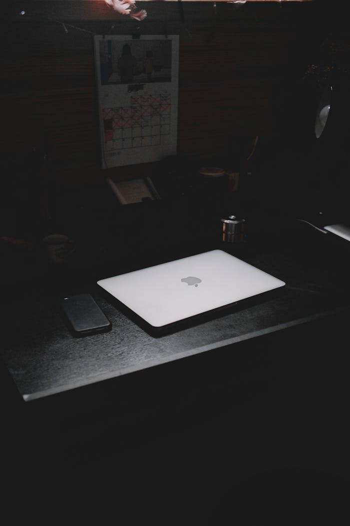Services A dark, minimalist workspace featuring a laptop and smartphone on a desk.